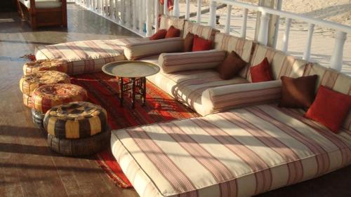 Habitación con sofás y balcón con mesa. en Dahabiya Giraffa, en Luxor