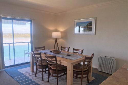 a dining room with a table and chairs and a window at Estuary in Nambucca Heads