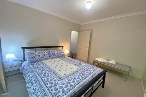 a bedroom with a bed with a blue and white comforter at Estuary in Nambucca Heads