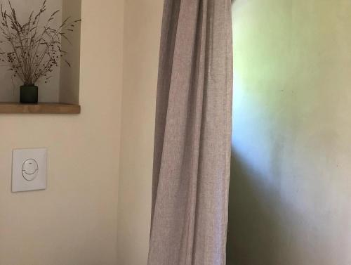 una cortina en una esquina de una habitación con un interruptor de luz en Fleurs de lin, 