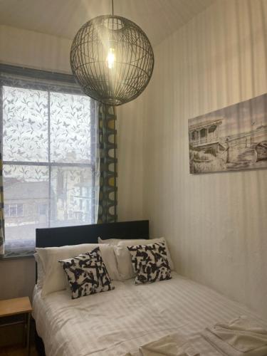 a bedroom with a bed with a chandelier above it at Lovely 2 Bed Sea Front apartment @ 10A George Street in Ryde
