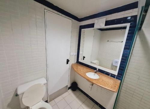 uma casa de banho com um lavatório, um espelho e um WC. em VICTORY BUSINESS FLAT TAMBAU em João Pessoa