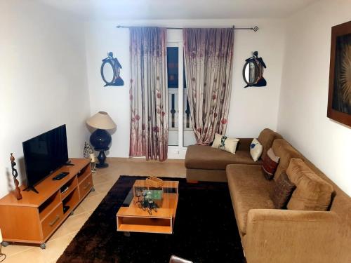 a living room with a couch and a tv at SOL AZUL in Santa Maria
