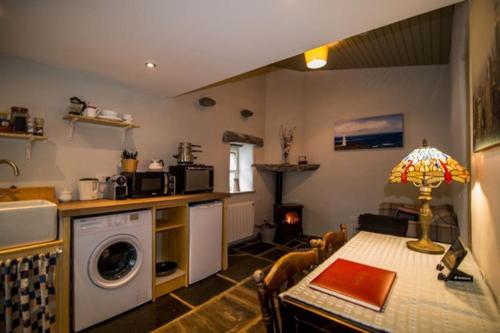 eine Küche und ein Esszimmer mit einem Tisch und einem Herd in der Unterkunft Glynn's Charming cottage in the Burren in Fanore