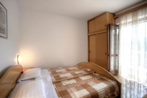 a bedroom with a bed and a window at White house in the forest in Pučišća