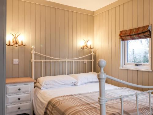 1 dormitorio con cama blanca y ventana en Grouse Lodge en Scarborough
