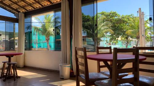 a room with a table and chairs and a window at Suites Arraial do Cabo in Arraial do Cabo