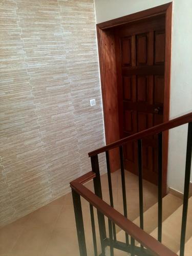 Una escalera que conduce a una habitación con puerta de madera en SOL AZUL en Santa María