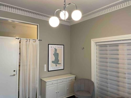 a bathroom with a mirror and a chair and a window at Cozy 4-Bedroom Apartment Aalborg in Aalborg