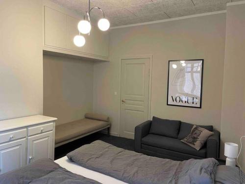 a bedroom with a bed and a couch and a chair at Cozy 4-Bedroom Apartment Aalborg in Aalborg