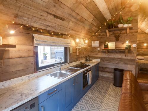 a kitchen with blue cabinets and a sink in a cabin at Foxes Den in Scarborough