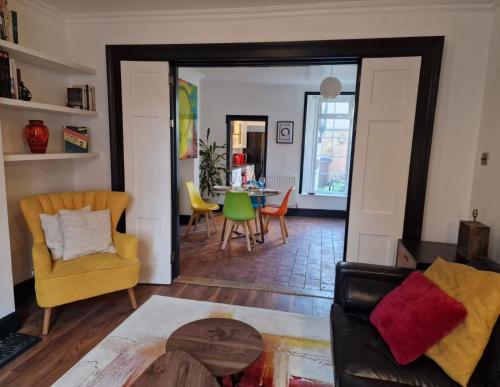 a living room with a yellow chair and a table at No.2 Boutique Art Townhouse  in Lincolnshire