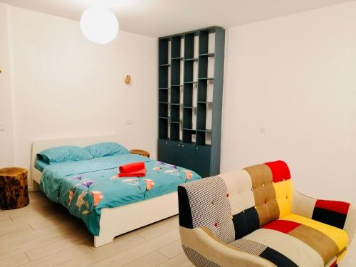 1 dormitorio con 1 cama y 1 silla en PLAZA VIEW Studio, en Bucarest