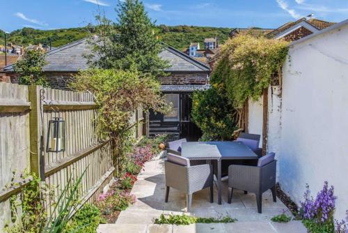 een patio met een tafel en stoelen en een hek bij Modern living, Charming Old Town Cottage in Hastings