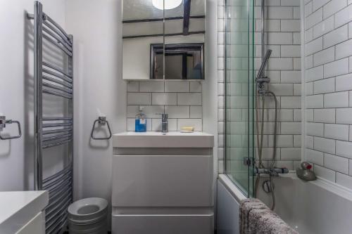 a small bathroom with a sink and a shower at Charming Old Town Cottage With Modern Features in Hastings