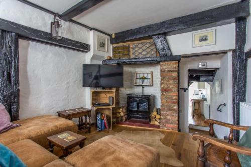 a living room with a fireplace and a tv at Charming Old Town Cottage With Modern Features in Hastings