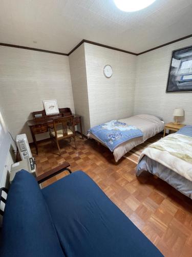 a room with two beds and a desk in it at brompton tabinoyado - Vacation STAY 66538v in Awa