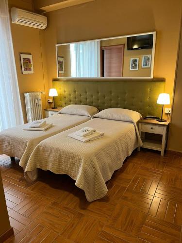 a bedroom with two beds and a mirror at B&B Corso Porta Nuova 39 in Verona