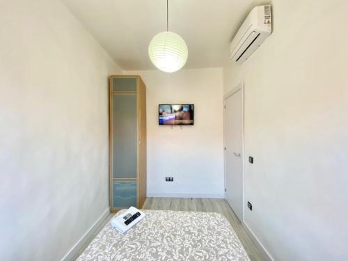 un pasillo con una habitación con TV en la pared en Piramides 1 Apartment en Madrid