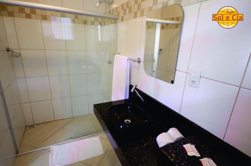 a bathroom with a black sink and a mirror at Pousada Sol e Cia Tur in Caraguatatuba