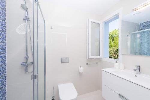 ein weißes Bad mit einer Dusche und einem Waschbecken in der Unterkunft NEW! Villa Lago B, Alcudia Beach, Mallorca in Port d'Alcúdia