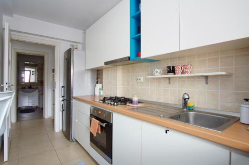 uma cozinha com um lavatório e um fogão em Brates Apartment em Iaşi