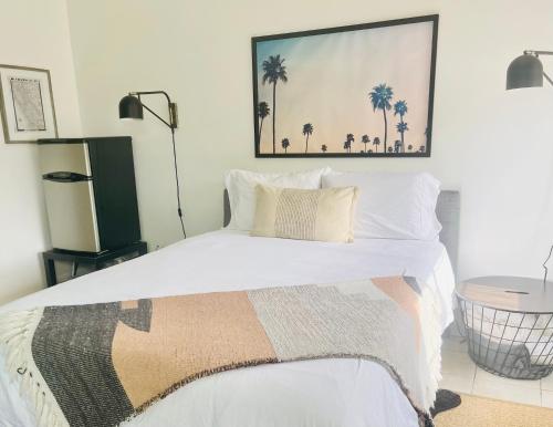 a bedroom with a bed with a picture on the wall at Spotless Modern studio in Inglewood