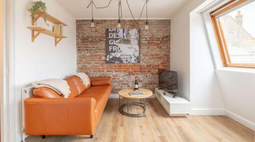 a living room with a couch and a brick wall at Cracking Central Loft Apartment, Old Town in Hastings