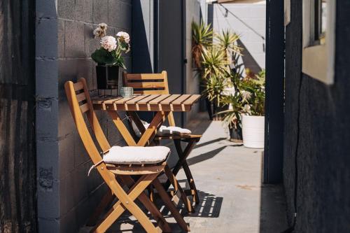 une table et des chaises en bois assises sur un trottoir dans l'établissement Spotless Modern studio, à Inglewood