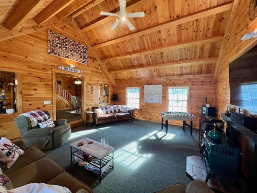 una gran sala de estar con paredes de madera y techo. en Log Home w Mountain Views Near Windham & Hunter Ski Resorts, en Maplecrest