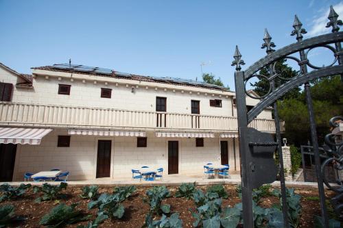 a building with tables and chairs in front of it at White house in the forest in Pučišća