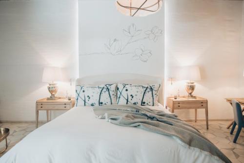 a bedroom with a white bed with two tables and two lamps at LOtel-Casa Arca in San Miguel de Allende