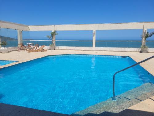 una gran piscina azul con vistas al océano en Apartamento com Vista para o Mar en Guarapari