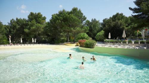 un gruppo di persone che nuotano in piscina di Appartement vue panoramique au domaine et golf de pont royal a Mallemort