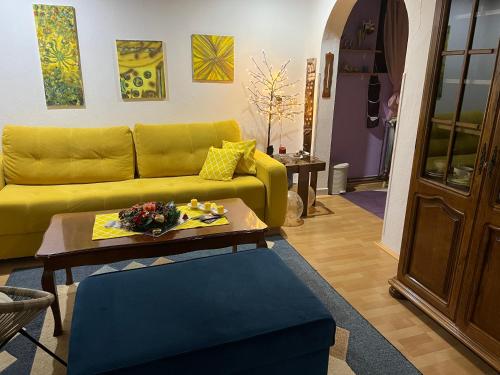 a living room with a yellow couch and a table at Apartman SI in Banja Luka