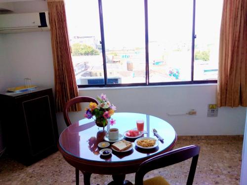 una mesa con un plato de comida y flores en ella en Hotel Khalifa, en Neiva