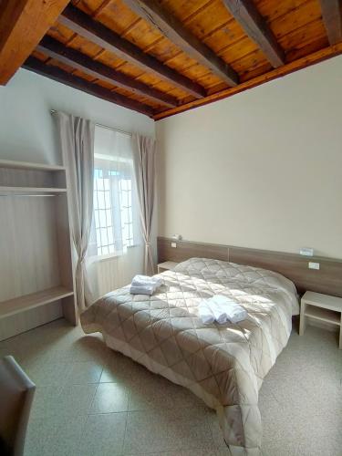 1 dormitorio con 1 cama con 2 toallas en La Corte Felice, en San Donato Milanese