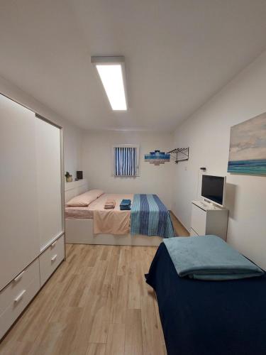 a bedroom with two beds and a television in it at B&B ARTHAS in Capilungo