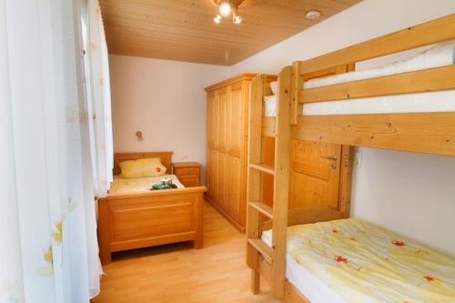 a bedroom with two bunk beds and a desk at Aignerhof in Kirchberg