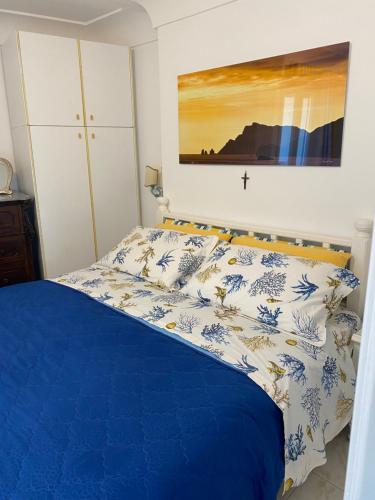 a bedroom with a blue and white bed with a cross on the wall at Longano 35 in Capri