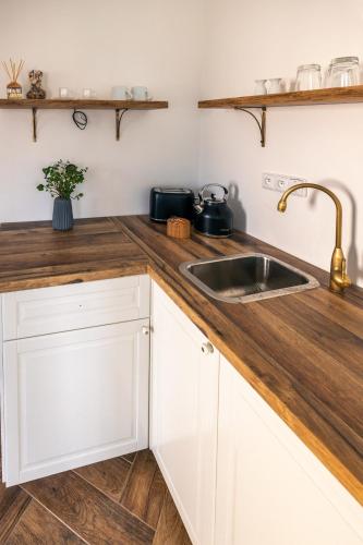 a kitchen with white cabinets and a sink at Penzion Fara pod Milešovkou in Velemín