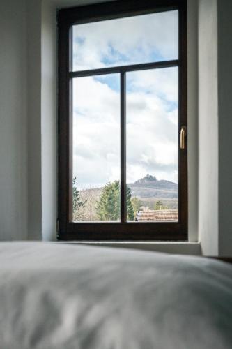 a bedroom with a window with a view of a mountain at Penzion Fara pod Milešovkou in Velemín