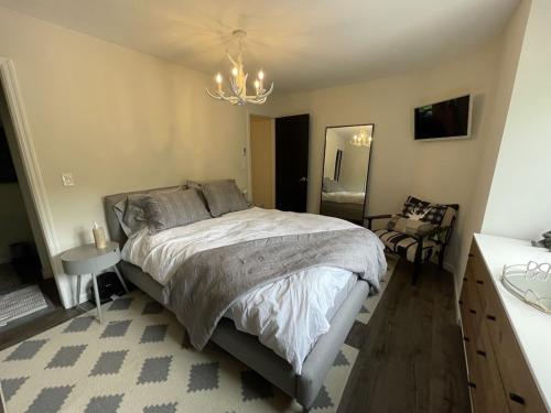 a bedroom with a large bed and a chandelier at Mountain Condo with Modern Cabin Style in East Jewett