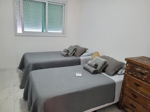 2 camas en un dormitorio con ventana y vestidor en Apartamento Florianópolis Canasvieiras, en Florianópolis