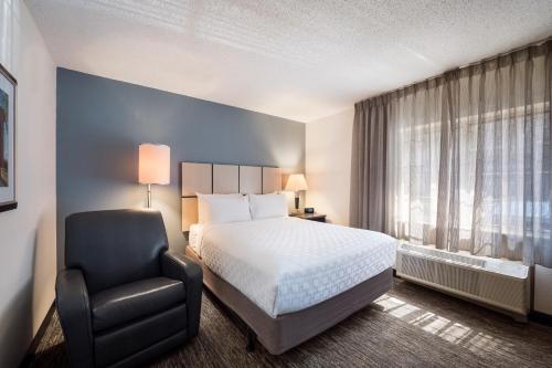 um quarto de hotel com uma cama e uma cadeira em Sonesta Simply Suites Nanuet em Nanuet