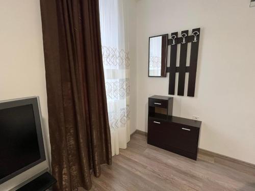 a living room with a television and a dresser at Pension NV in Lutherstadt Eisleben