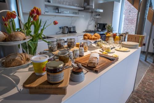 un bancone della cucina con pane e cibo sopra di Ô Macra B&B - Aubel, Pays de Herve ad Aubel