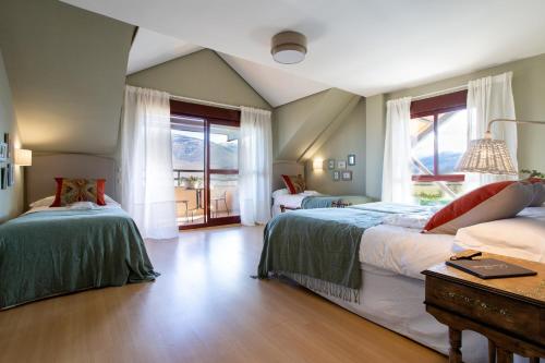 リアサにあるSAN BENITO LA CASA DE MIS ABUELOSのベッドルーム1室(ベッド2台、大きな窓付)