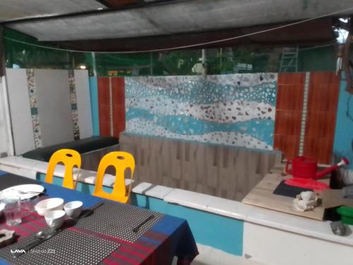 Ocean Way Guraidhoo في غوريدهو: غرفة لعب مع طاولة وكراسي صفراء