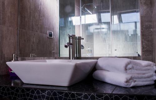 y baño con lavabo y toallas en la encimera. en Hotel & Apartments Davesa House, en Cusco